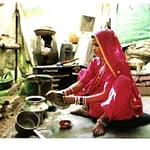 nainen pesee astioita kotinsa keittiössä pukeutuneena sariin, Rajasthan, Intia
