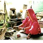 nainen pesee astioita kotinsa keittiössä pukeutuneena sariin, Rajasthan, Intia