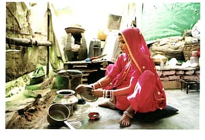 nainen pesee astioita kotinsa keittiössä pukeutuneena sariin, Rajasthan, Intia